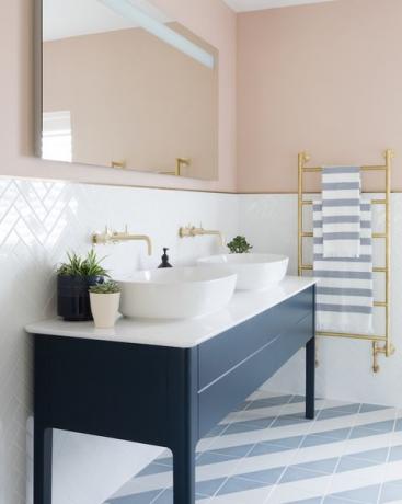 Salle de bain rose avec des carreaux graphiques et un lavabo bleu marine pour elle et lui