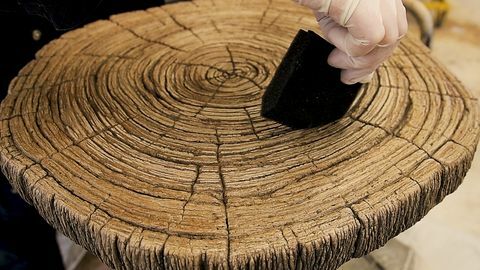 Image gros plan moyen d'un accrocher l'ajout de touches de finition à une table en faux bois après l'application du revêtement final