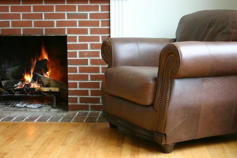 Chaise en cuir, mur en brique et cheminée