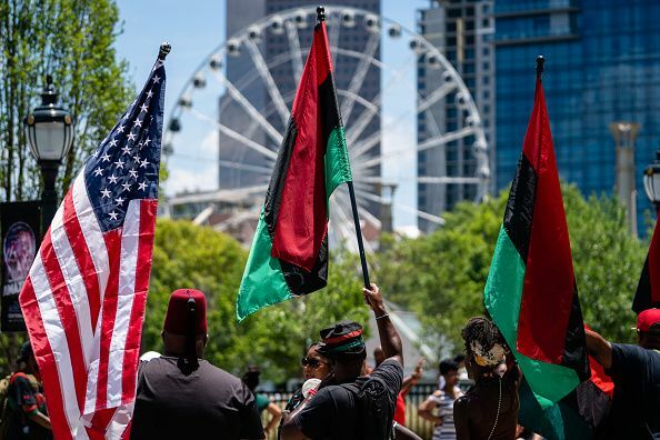 atlanta, ga 18 juin les gens lèvent des drapeaux américains et panafricains en marchant dans le défilé de l'histoire des noirs d'atlanta le 18 juin 2022 à atlanta, le 19 juin aux états-unis, ou jour de l'émancipation, commémore la fin de l'esclavage mobilier le 19 juin 1865 à galveston, texas, conformément au président lincolns 1863 proclamation d'émancipation en 2021, le président américain joe biden a signé une loi déclarant le 19 juin un jour férié fédéral photo par elijah nouvelagegetty images