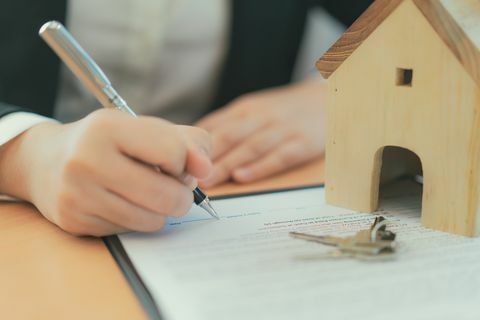 Contrat d'achat de maison concept, femme d'affaires signant un contrat d'achat de maison.