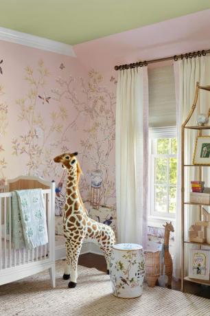 papier peint rose, jouet en peluche girafe, lit de bébé, tapis crème