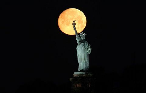 La Lune se cache derrière la Statue de la Liberté à New York