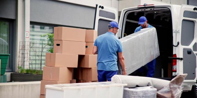 travailleurs masculins en uniforme bleu déchargeant des meubles