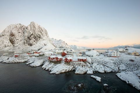 Maison de pêche rouge village parmi la neige avec vue sur la montagne dans l'île des Lofoten Hamnoy Norvège