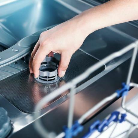 partie du filtre du lave-vaisselle dans la main masculine, service de nettoyage de la machine à laver la vaisselle d'appareils ménagers à l'intérieur,