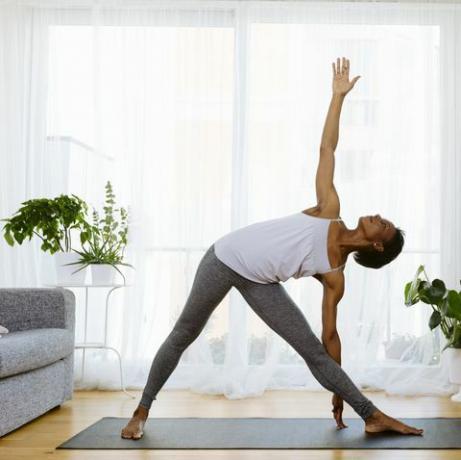 Femme pratiquant le yoga à la maison