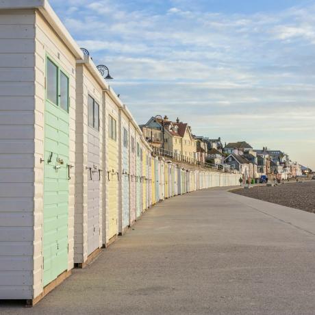 Cabines de plage aux couleurs pastel bordent la promenade à Lyme Regis, Dorset