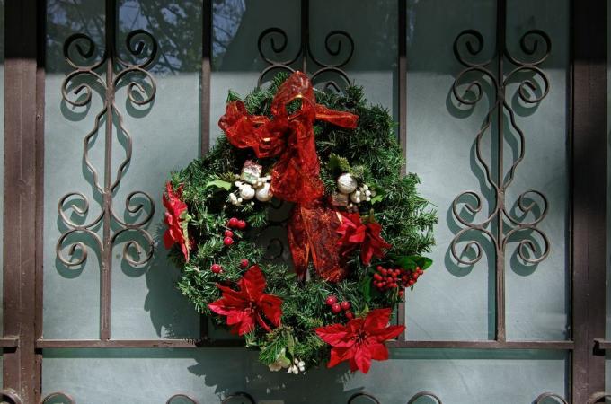 couronne de Noël sur une élégante porte d'entrée en fer forgé et en verre dépoli