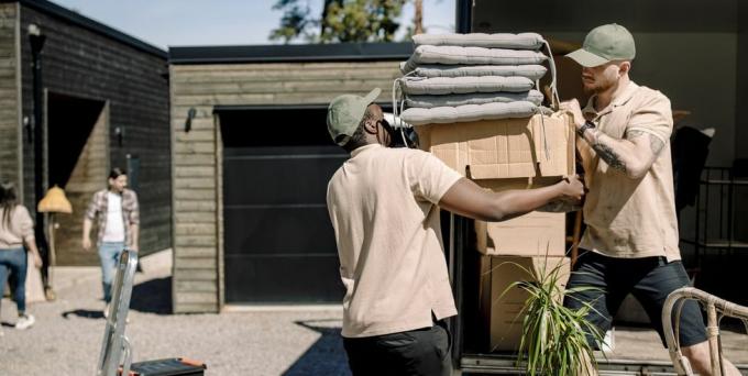 livreurs ramassant des boîtes en carton dans un camion pendant la journée ensoleillée