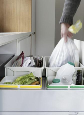 Personne retirant le sac poubelle du tiroir à déchets et de recyclage