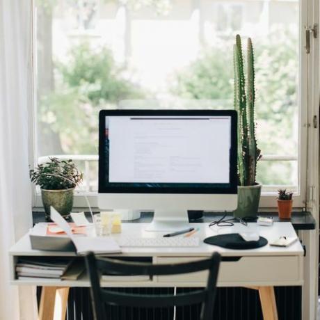 Femme affaires, debout, porte, ordinateur, bureau, maison, bureau