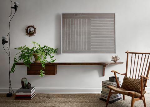 salon, murs peints en blanc, étagère ouverte en bois, plante, chaise assise en bois