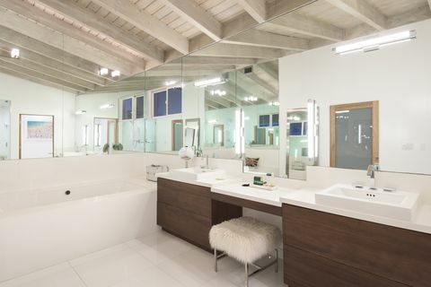 salle de bain moderne avec armoires brunes et un grand miroir