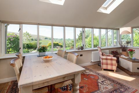 Salle à manger d'inspiration champêtre avec de grandes fenêtres