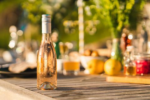 une bouteille non ouverte de vin rosé froid sur une table de dîner au milieu de l'été en suède se concentrer sur la bouteille fraîche dégoulinante au premier plan