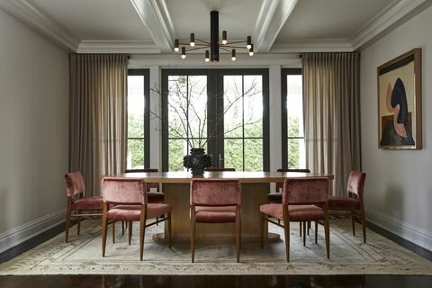 salle à manger, murs blancs, table à manger marron avec chaises en velours rouge