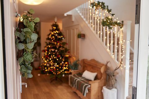 Couloir de la maison décoré pour Noël vu à travers la porte d'entrée