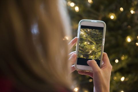 Femme, photographier, arbre noël, à, téléphone portable