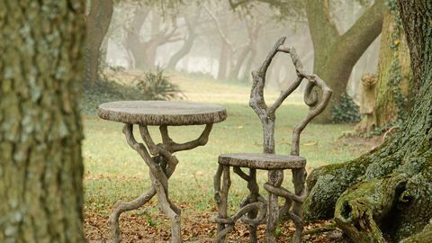 Une image d'une chaise et d'une table en faux bois au milieu des arbres un jour brumeux