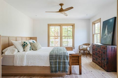 chambre à coucher, cadre de lit en bois, commode ancienne rouge avec des œuvres d'art sur le dessus