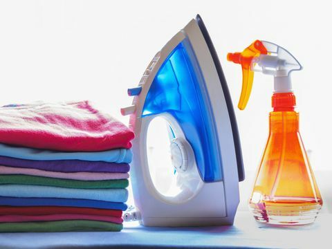 Fer, vaporisateur et tas de linge propre