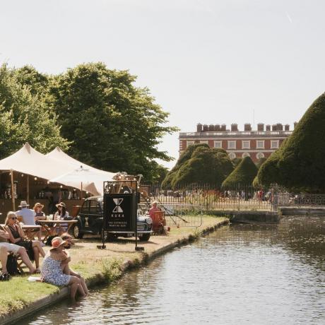 les visiteurs se détendent au bar kuka au bord de l'eau au rhs hampton court palace garden festival 2022