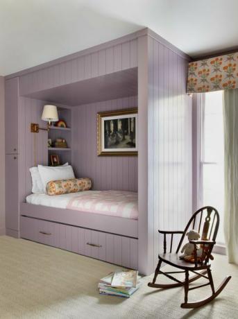 chambre d'enfant, lit cubby violet, chaise berçante marron, rangement sous le lit, rideaux floraux