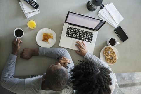 Vue aérienne du couple à l'ordinateur portable dans la cuisine