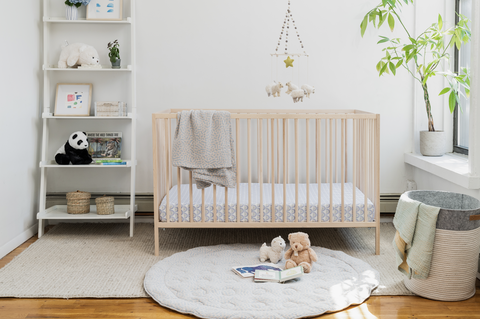 chambre bébé avec berceau et tapis de jeu