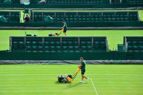 Le personnel au sol tond l'herbe sur un court au All England Lawn Tennis Club à Wimbledon