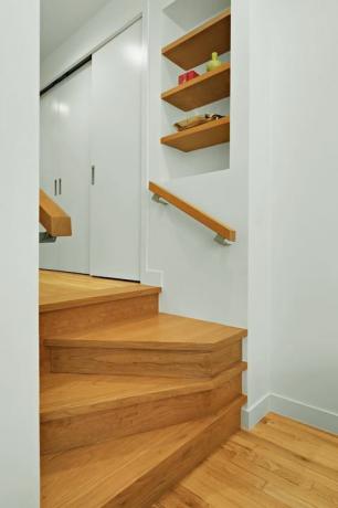 Escalier de poche: un escalier moderne personnalisé à quatre marches mène au couloir, forme un mini palier avec des étagères à mi-chemin.