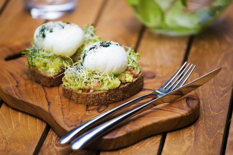 Tranches de pain grillé avec purée d'avocat, œuf à la coque et germes